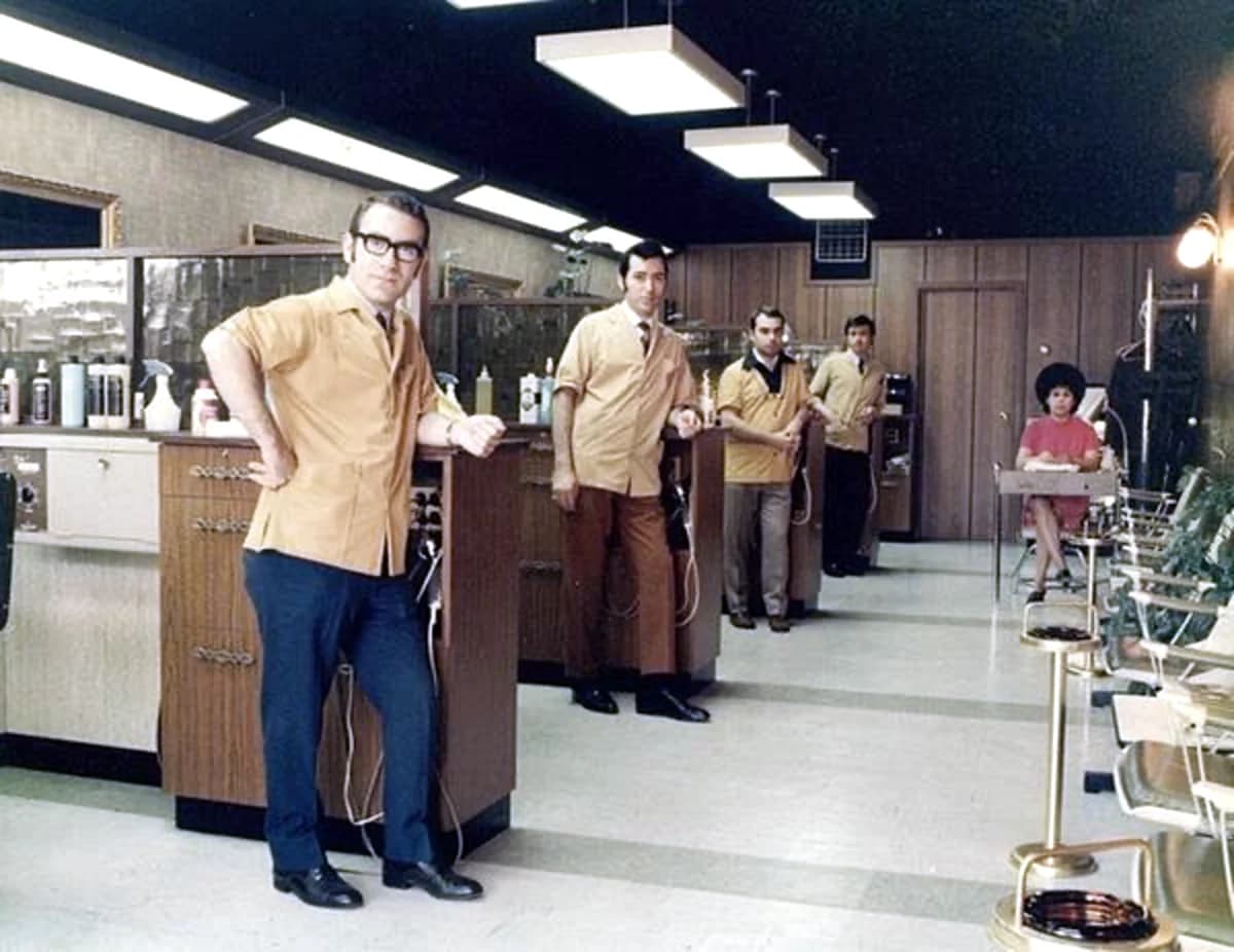 Five barbers in matching shirts lined up inside Madison's